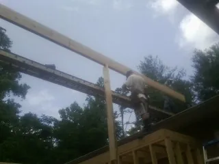 Carpenter setting a ridge beam over a new addition frame — Ice Dam Removal by Roofing Brothers in Ritzville