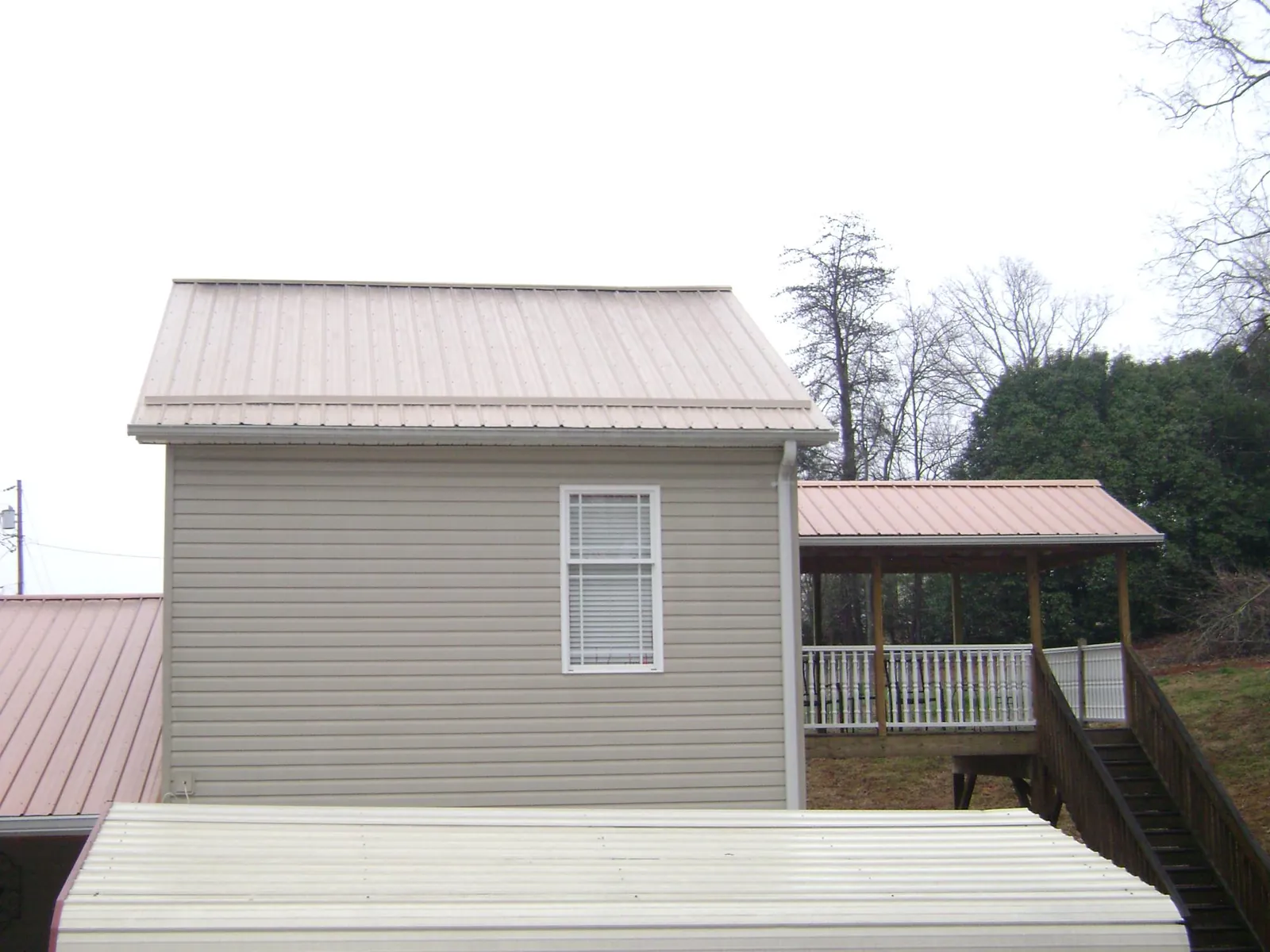 Tan metal roofs on a two story addition and attached porch, from a Roof Replacement job in Ritzville